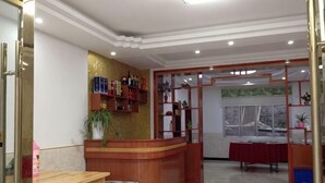 Zona de recepción con mostrador de madera, una mesa y una ventana con vistas.