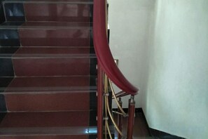 Eine Treppe mit roter Handlauf und Teppichboden.