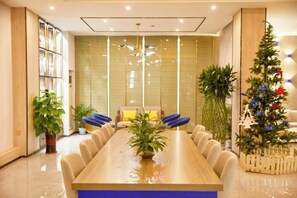 A conference room with a long table, chairs, and a Christmas tree. - 7 Days Premium (Zhongshan)