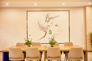 A conference room with a long table, six chairs, and two potted plants. - 7 Days Premium (Zhongshan)