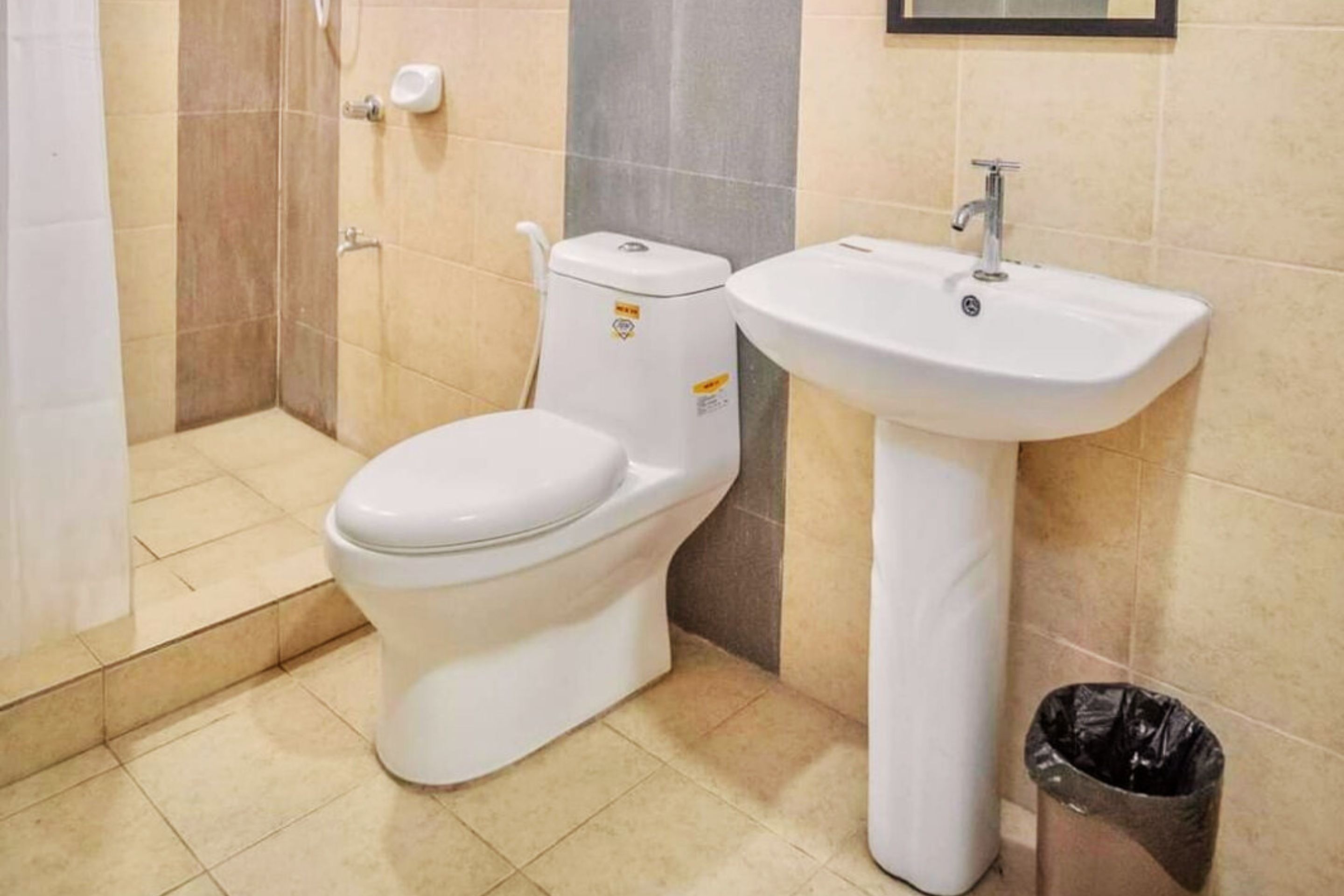 Kylpyhuone, jossa on wc, pesuallas ja roskakori.