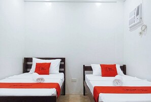 Two single beds with white bedding and red accents, a white wall, and a ceiling-mounted air conditioning unit. - Reddoorz @ David's Travellers Inn Cavite (General Trias)