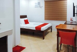 A hotel room with a bed, a desk, and a chair. - Reddoorz @ David's Travellers Inn Cavite (General Trias)