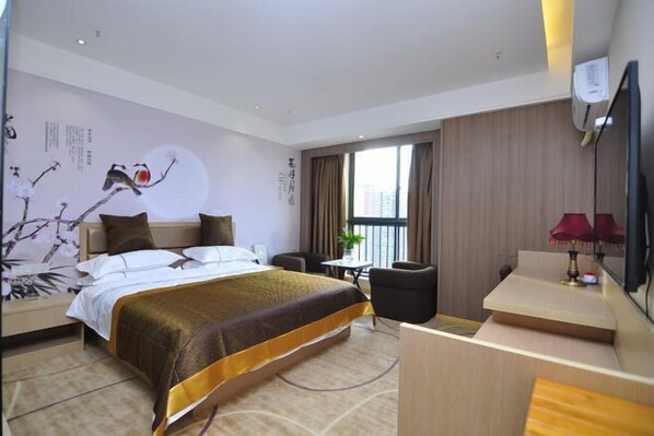 Une chambre d’hôtel avec un grand lit, un bureau, une chaise, une télévision et une fenêtre avec des rideaux.