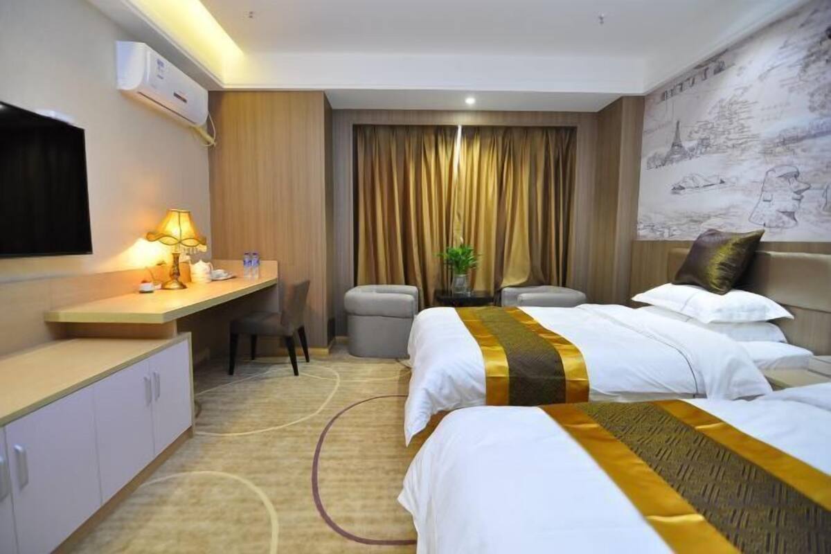 Une chambre d’hôtel avec un lit, un bureau, une télévision et un rideau.