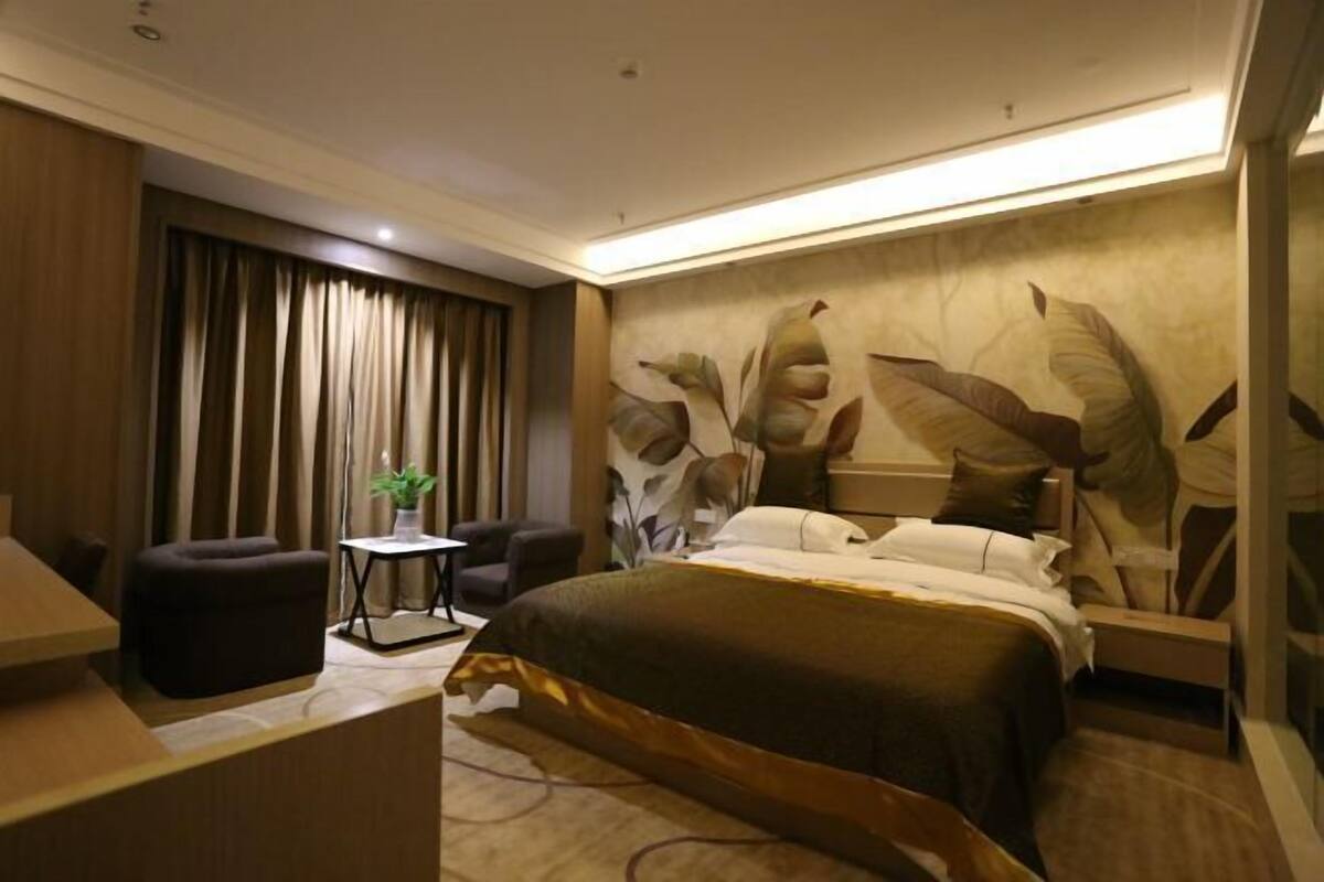 Une chambre d’hôtel moderne avec un grand lit, un bureau, une chaise et une petite table.