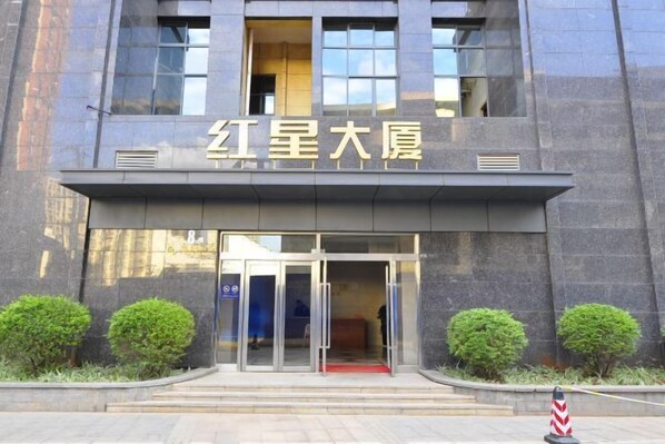 A building entrance with a sign reading "红星大厦" and a glass door.
