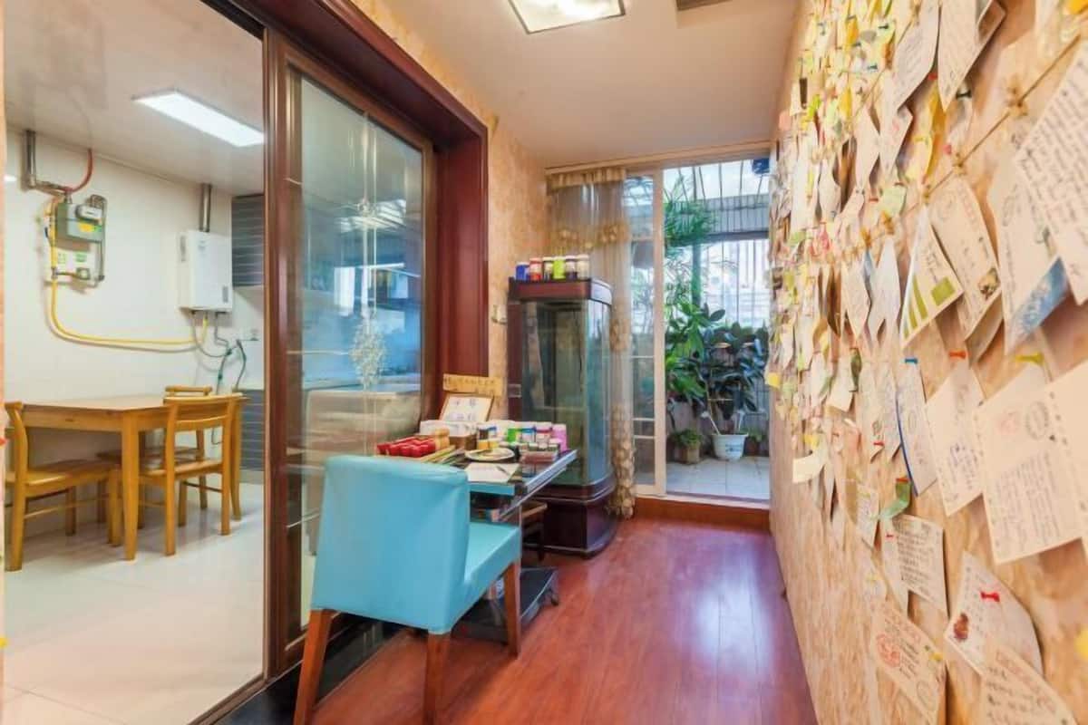 Une pièce comprenant une table à manger en bois, une chaise bleue, un réfrigérateur et un mur recouvert de notes.