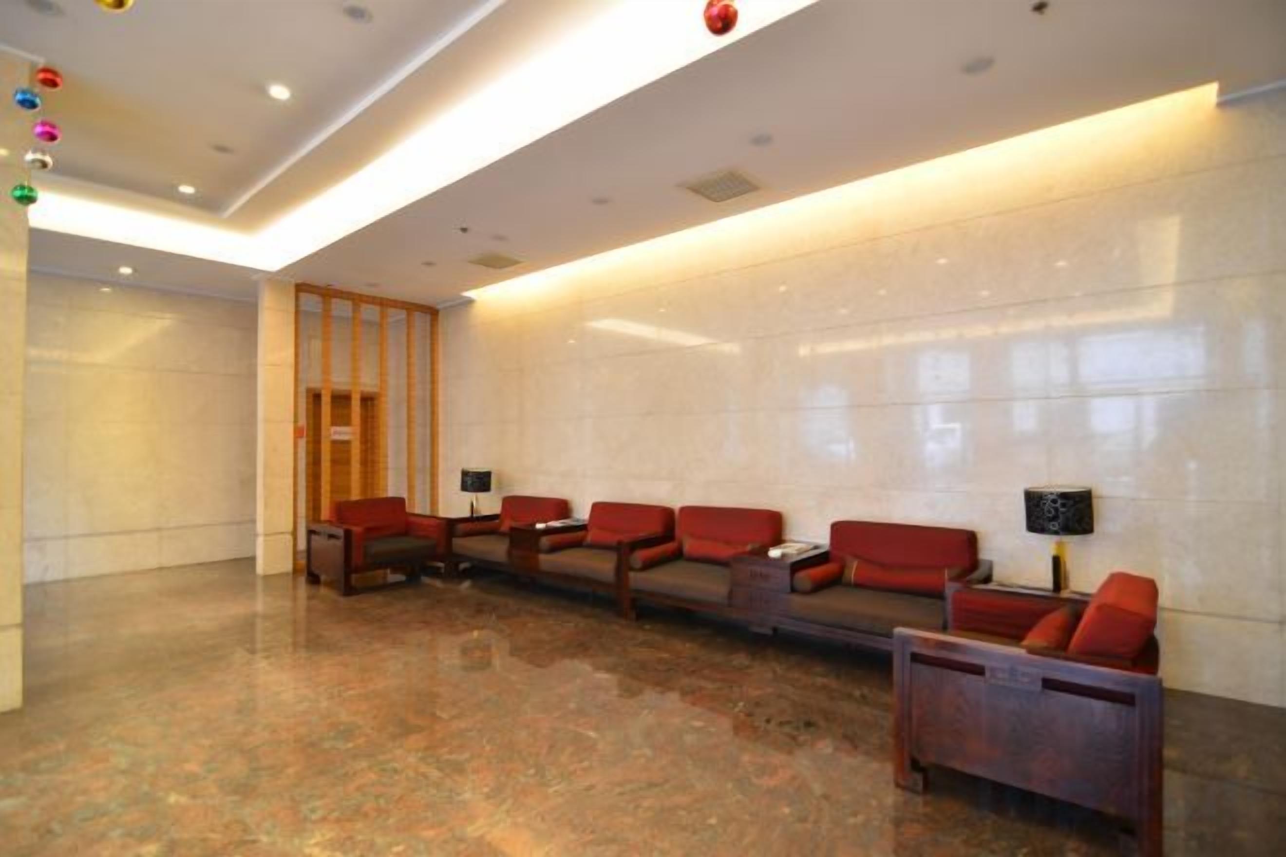 A lobby with a reception desk, seating area, and a wooden door.