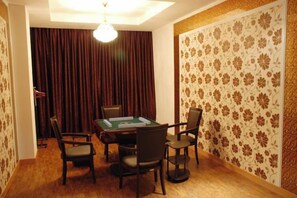 A room with a table and chairs, a chandelier, and patterned wallpaper. - Jinyuwan Hotel (Dalian)