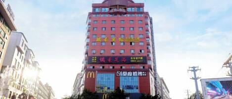 A multi-story hotel with a prominent McDonald's sign, multiple windows, and a large digital screen on the facade.