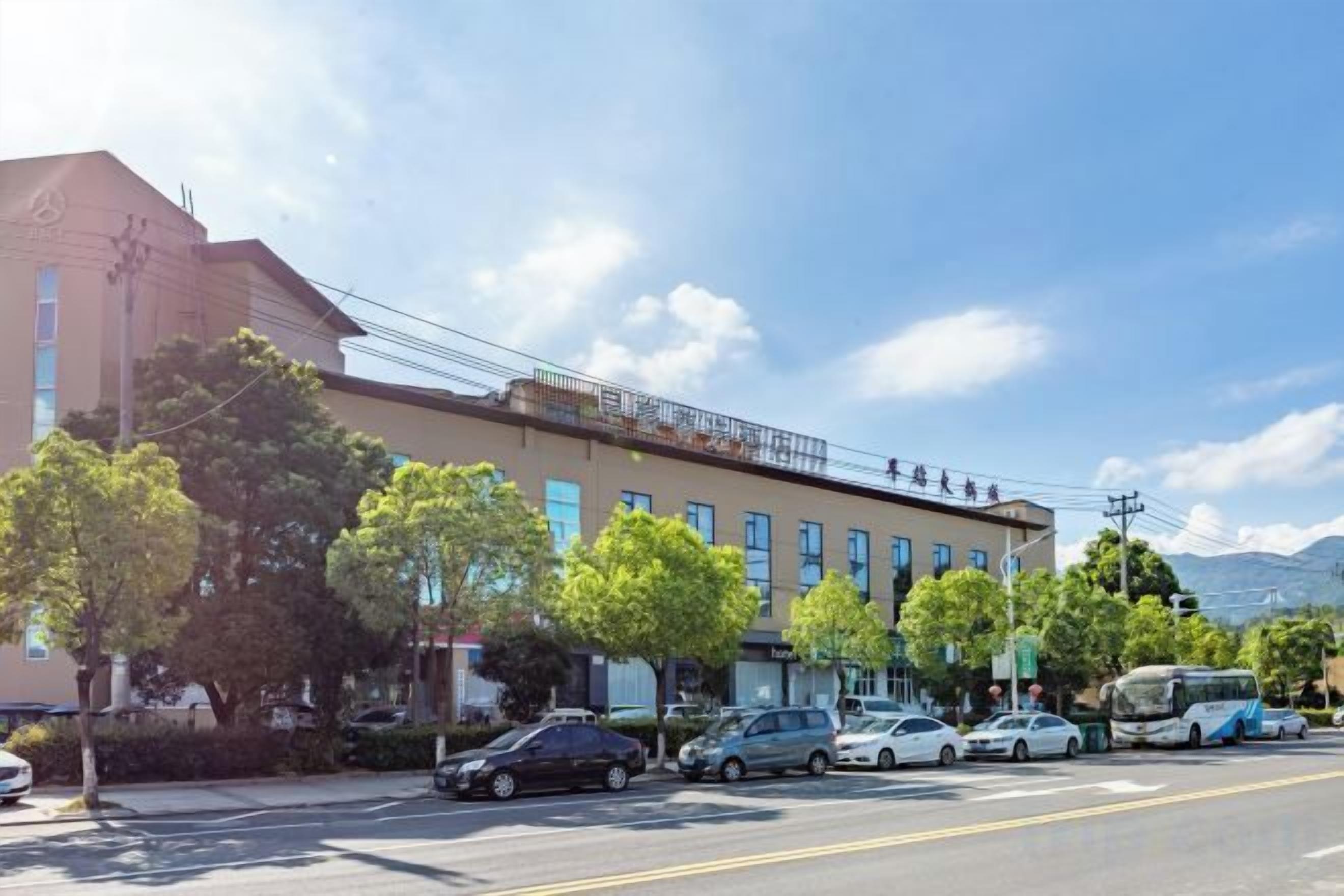 Un edificio de varios pisos con fachada plana, varias ventanas y un balcón en el nivel superior.