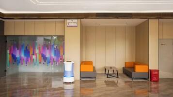 A lobby with a reception desk, seating area, and a colorful abstract wall.