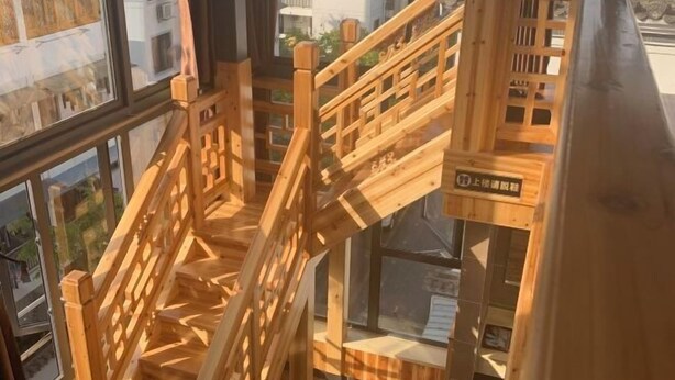 A wooden interior staircase with a view of the outside through large windows. - Hongcun Huifeng Yayun Hotel (Yi County)