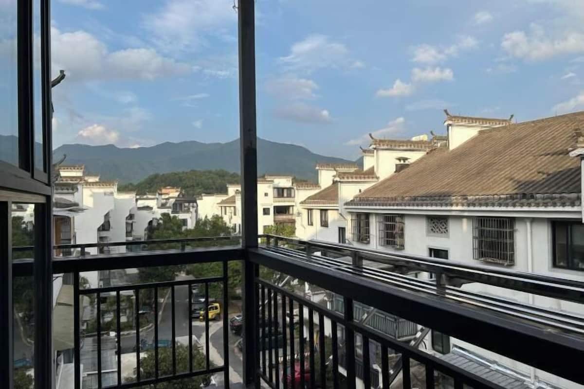 Un balcón con vistas a edificios tradicionales y montañas.