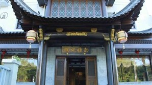 A traditional building entrance with a sign in Chinese characters, a tiled roof, and two lanterns. - Hongcun Huifeng Yayun Hotel (Yi County)