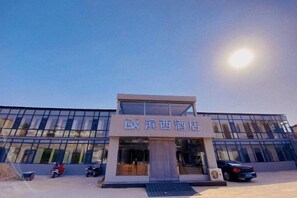 A modern hotel with a glass facade, a prominent entrance, and a clear sky. - Binxi Hotel (Linfen Yingbin Avenue Museum Branch) (Linfen)