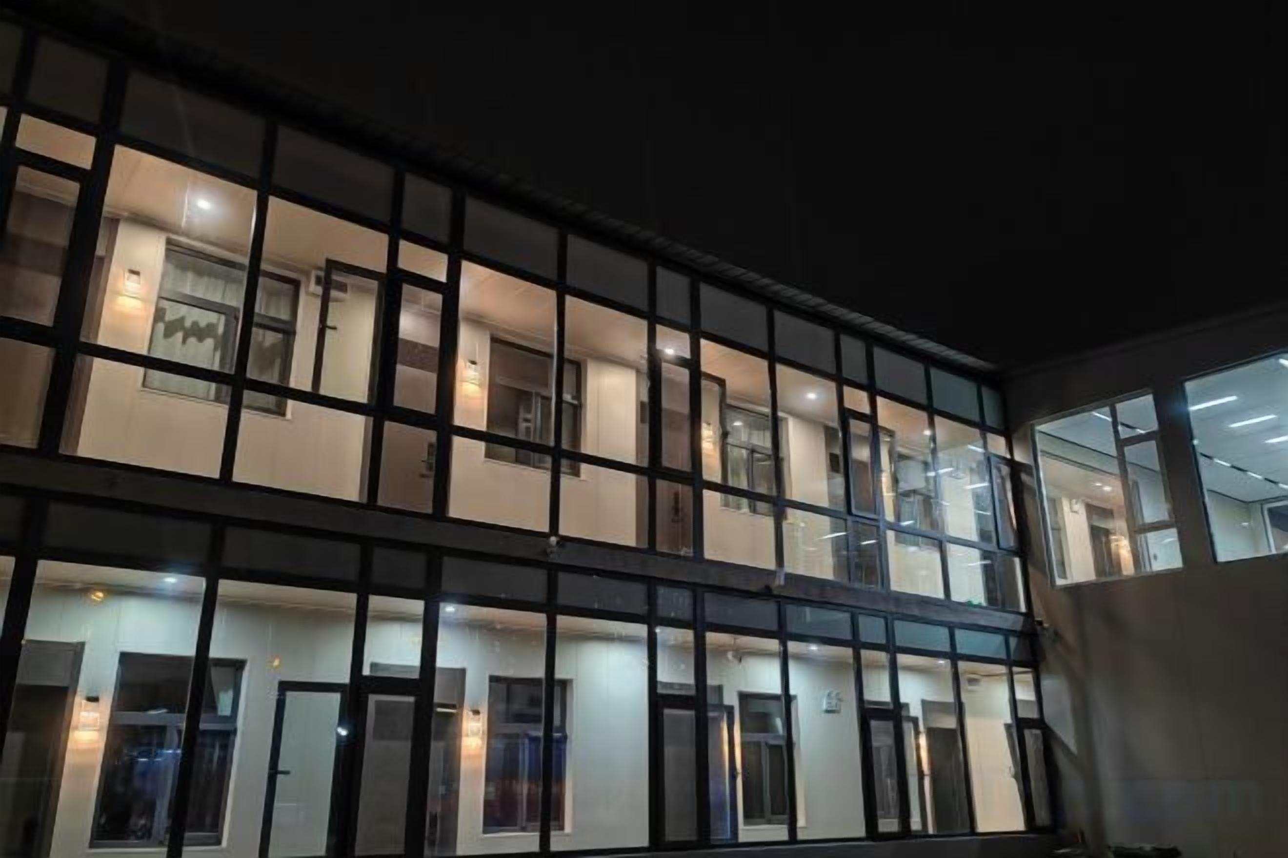 Un edificio de varios pisos con fachada de líneas rectas, ventanas amplias y puertas distribuidas uniformemente.