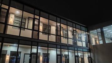 Un edificio de varios pisos con fachada de líneas rectas, ventanas amplias y puertas distribuidas uniformemente.