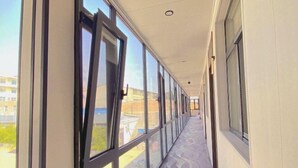 Um corredor com grandes janelas e um chão estampado.