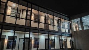 Um edifício de vários andares com fachada em forma de grade, janelas amplas e portas igualmente espaçadas.