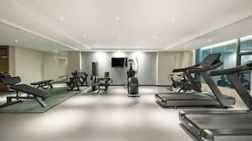 A gym with treadmills, weight machines, and benches.
