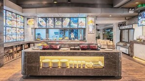 Un restaurant doté d’un comptoir en marbre, de plusieurs vitrines où sont exposés les plats, et d’un décor intérieur moderne.