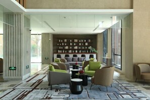 Un hall d’entrée moderne, doté d’un espace détente, d’un tapis à motifs et d’un mur agrémenté d’objets décoratifs.