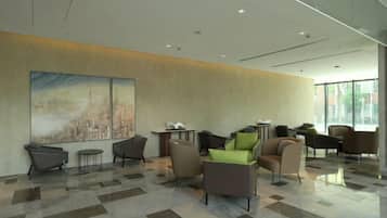 A lobby with a checkered floor, seating area, and large windows.