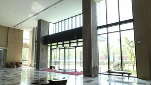 Un hall d’entrée spacieux, doté d’un sol ciré, de grandes fenêtres et d’espaces de détente modernes.