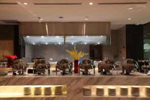 Un buffet avec plusieurs points de service et un présentoir central pour les plats.