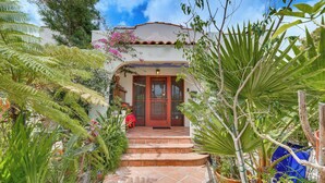 A traditional building with a red door, surrounded by lush greenery and a clear blue sky. - 2 Blocks to Melrose Ave! Home w/ Furnished Patio (Los Angeles)