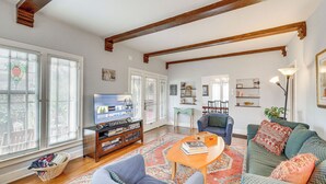 A spacious living room with a wooden ceiling, a television, a bookshelf, and a comfortable seating area. - 2 Blocks to Melrose Ave! Home w/ Furnished Patio (Los Angeles)