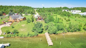 An aerial view of a property with a large house, a dock, and a forested area. - Riverfront Cheboygan Home w/ Dock ~ 4 Mi to Town! (Cheboygan)