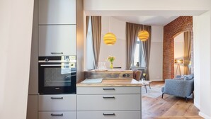 A modern kitchen with built-in appliances, a wooden countertop, and a dining area with a sofa and table. - Apartment 'Erstes Obergeschoss' with Wi-Fi (Cuxhaven)