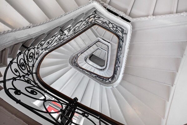 A spiral staircase with ornate metal railings and a white interior.