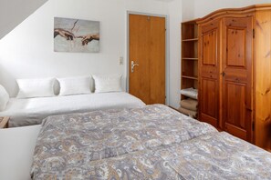 Une chambre à coucher avec un lit, une armoire et un tableau accroché au mur.