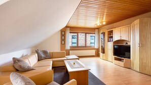 Una sala de estar moderna con un sofá, una mesa de centro y un televisor.