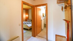 Een kamer met een bed, een houten deur en een radiator.