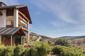 Un bâtiment à deux étages doté d’un balcon, d’un porche couvert et offrant une vue sur un paysage rural.