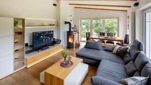 Een moderne woonkamer met een open haard, een televisie en een bank.