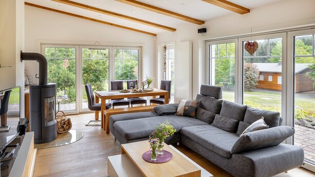 Een moderne woonkamer met een bank, een eettafel en een open haard.