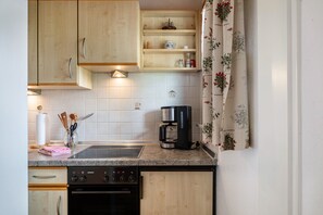 Een koelkast, een oven, een kookplaat, een koffiezetapparaat/waterkoker