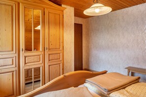 A wooden room with a bed, a wardrobe, and a small table. - Apartment 'Ferienwohnung Morgensonne' with Mountain View, Shared Garden and Wi-Fi (Breitnau)