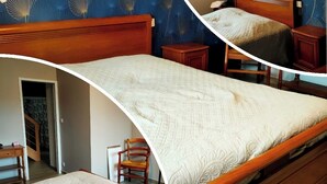 Une chambre à coucher avec un lit en bois, une table de chevet, une chaise et un papier peint à motifs.