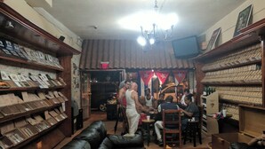 Un bar con estantes de madera, un televisor y un ventilador de techo.