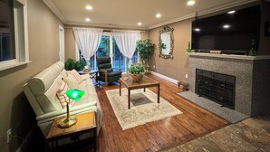 Una sala de estar con sofá, sillón, mesa de centro y chimenea.