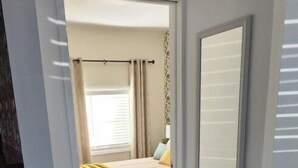 Une chambre à coucher avec un lit, des rideaux et une fenêtre.