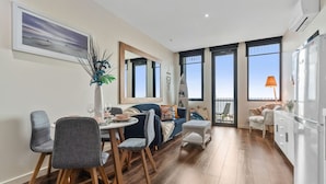 Een moderne keuken met een eetgedeelte, grote ramen en een balkon.