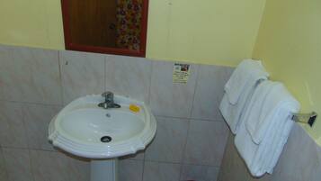 A bathroom with a white sink, a mirror, and a towel rack.
